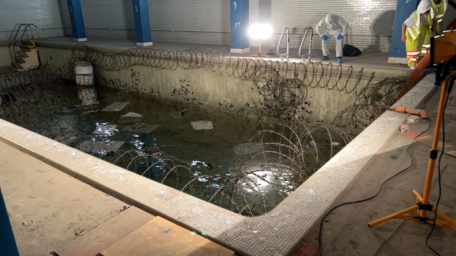 Forensic investigators examining a drained swimming pool crime scene in the horror mockumentary Strange Harvest